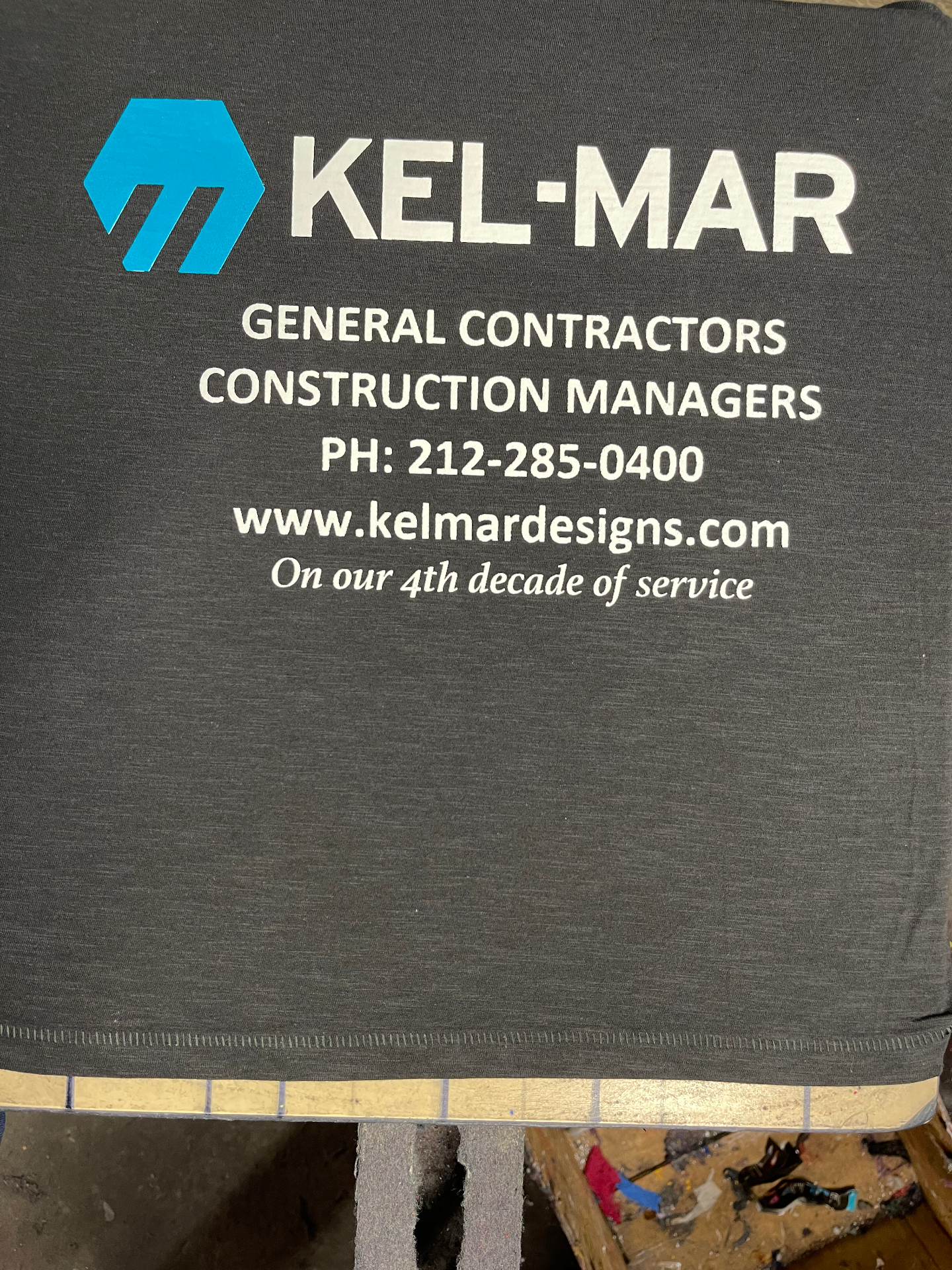 Gray Kel-Mar shirt printed with contractor branding and contact details.