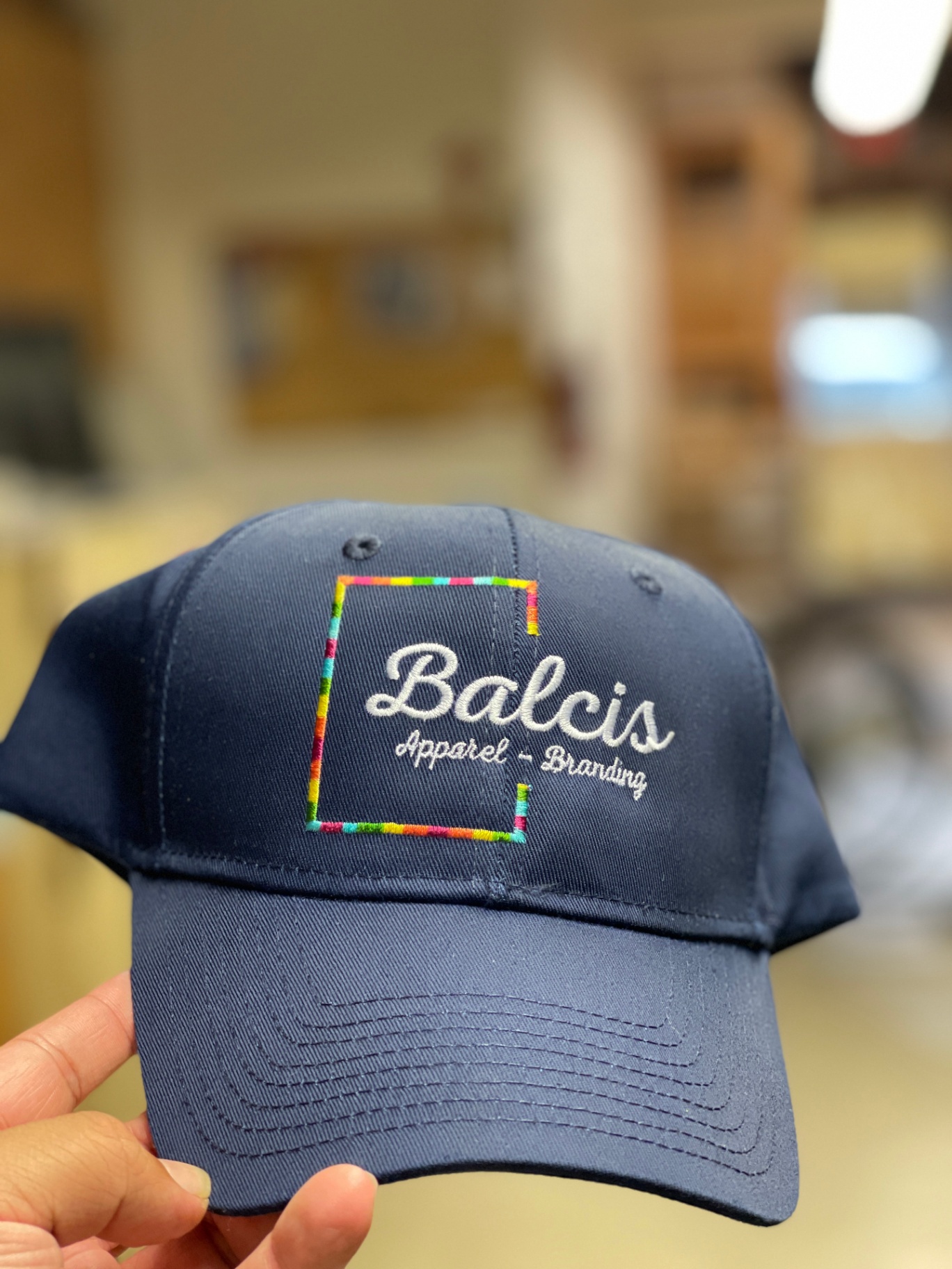 Navy Balcis Apparel Branding cap with colorful embroidered border.