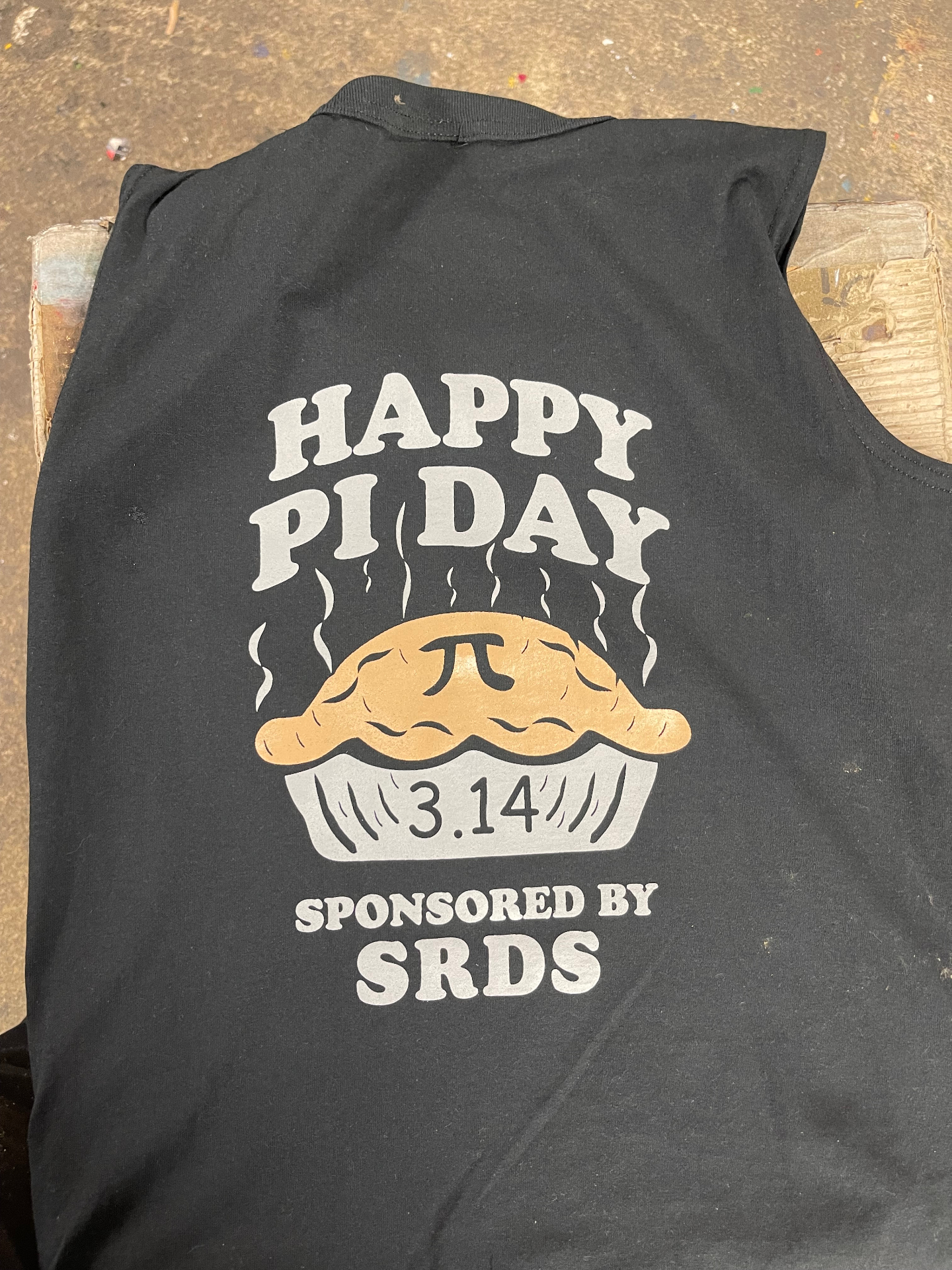 Black shirt printed with a Happy Pi Day pie design sponsored by SRDS.