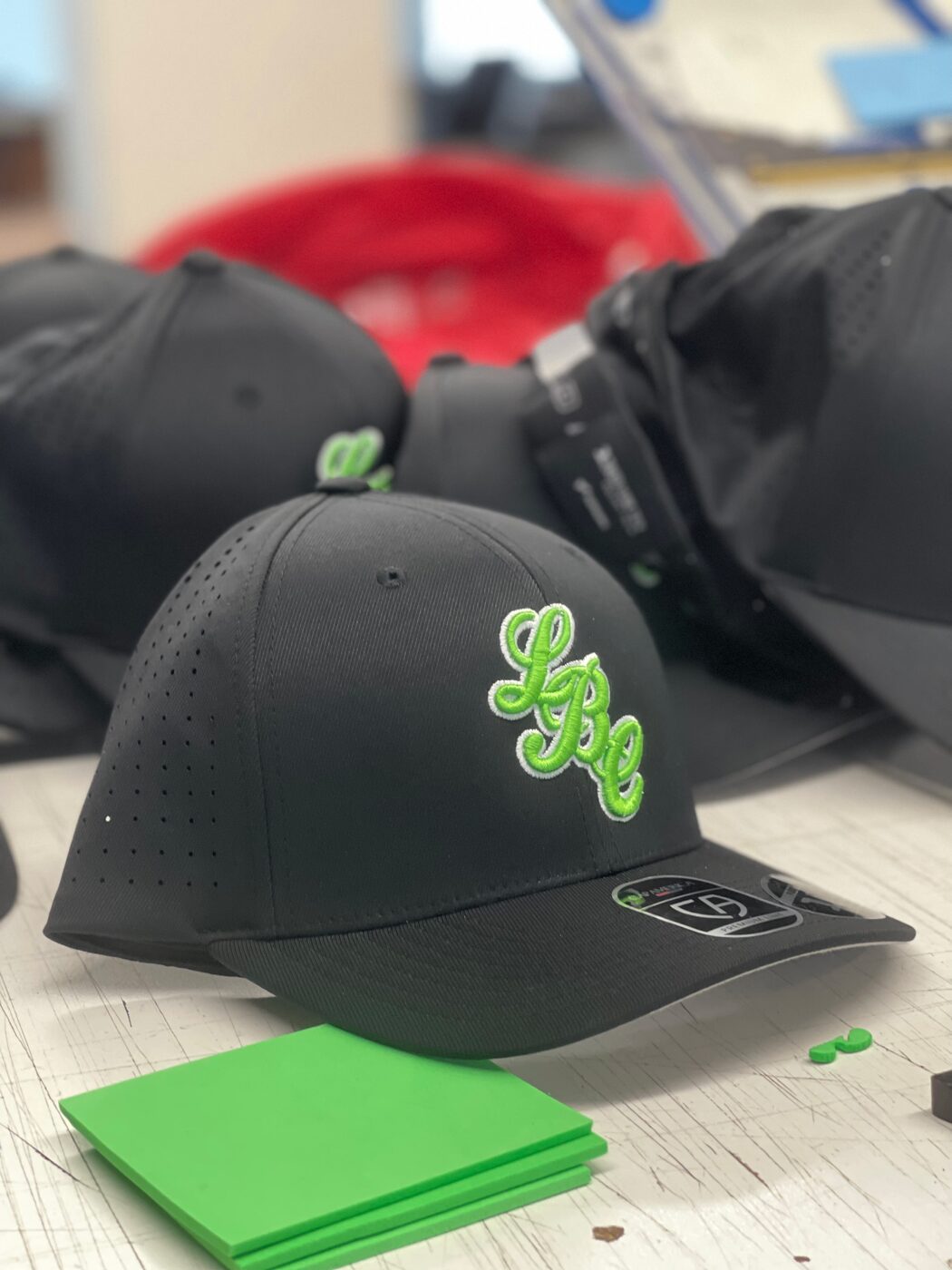 Black performance cap with neon green LBC script embroidery.
